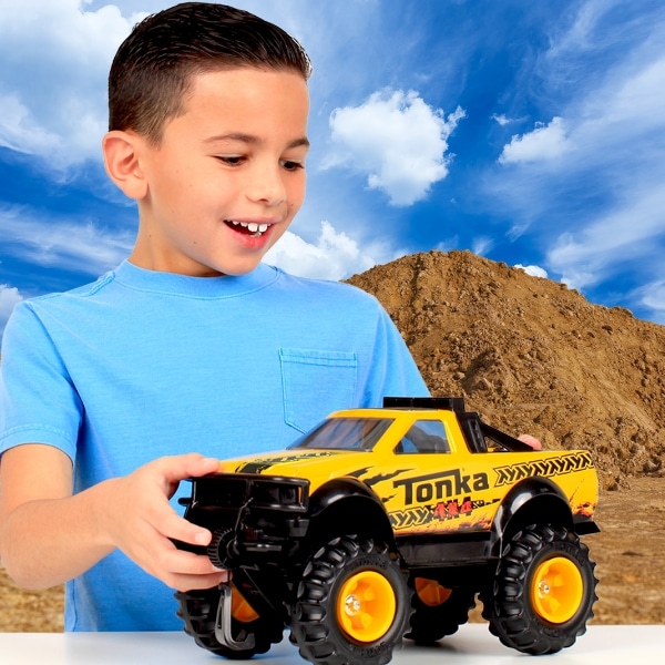 Young boy playing with Tonka Pickup Truck