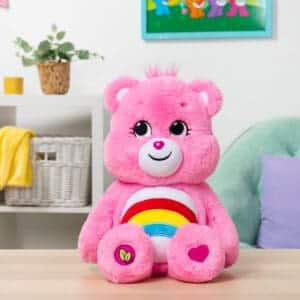 Care Bears Cheer plush displayed in a lifestyle setting on a desk.