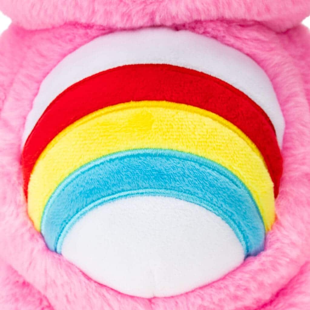 Close up of Care Bears Cheer Bear's belly, emphasizing the rainbow emblem.