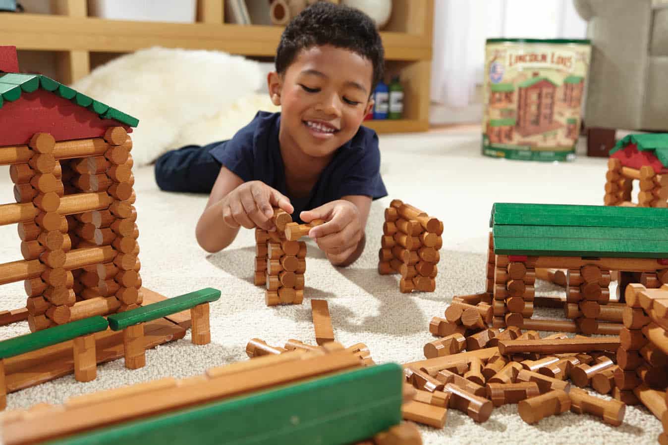 Boy playing with Lincoln Log Collectors Edition Tin.