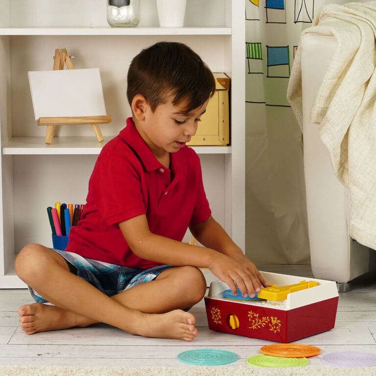 Boy playing with Fisher Price record player