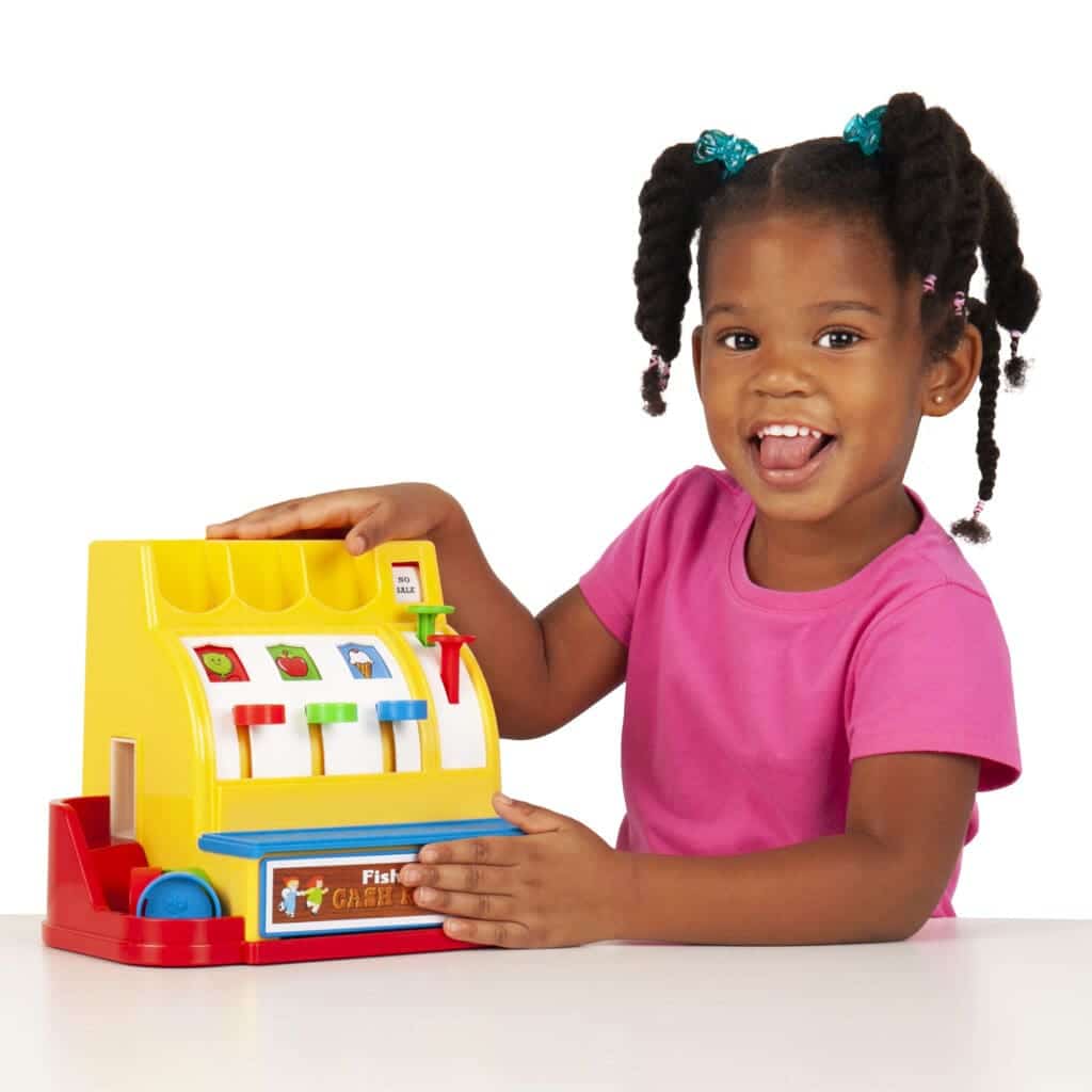 Girl holding Fisher-Price Classics Cash Register.