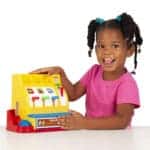 Girl holding Fisher-Price Classics Cash Register.
