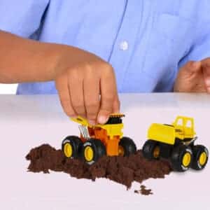 Child's hand playing with two Tonka Monster Metal Movers