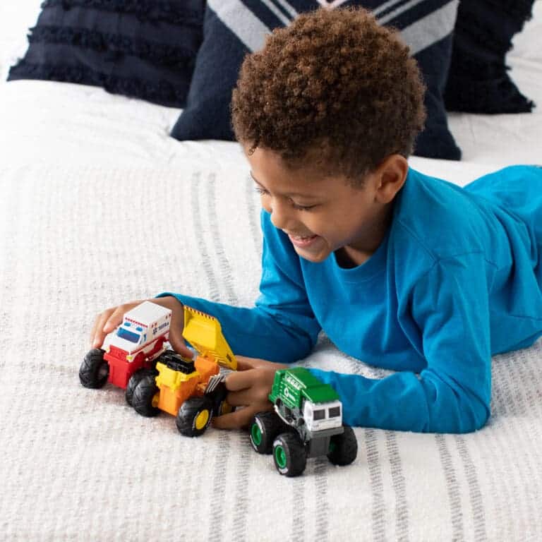 Boy playing with 3 Tonka Monster Metal Movers