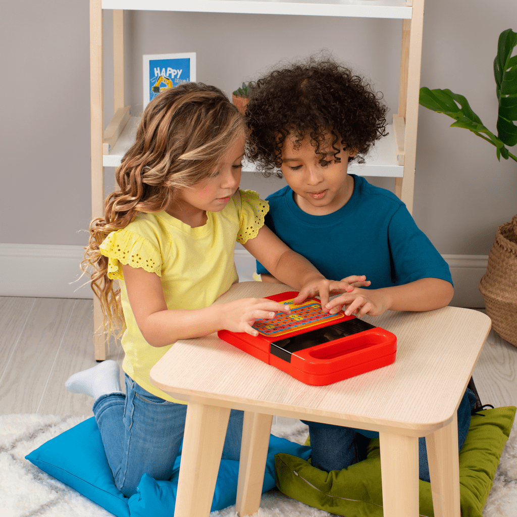 Two kids playing with speak and spell