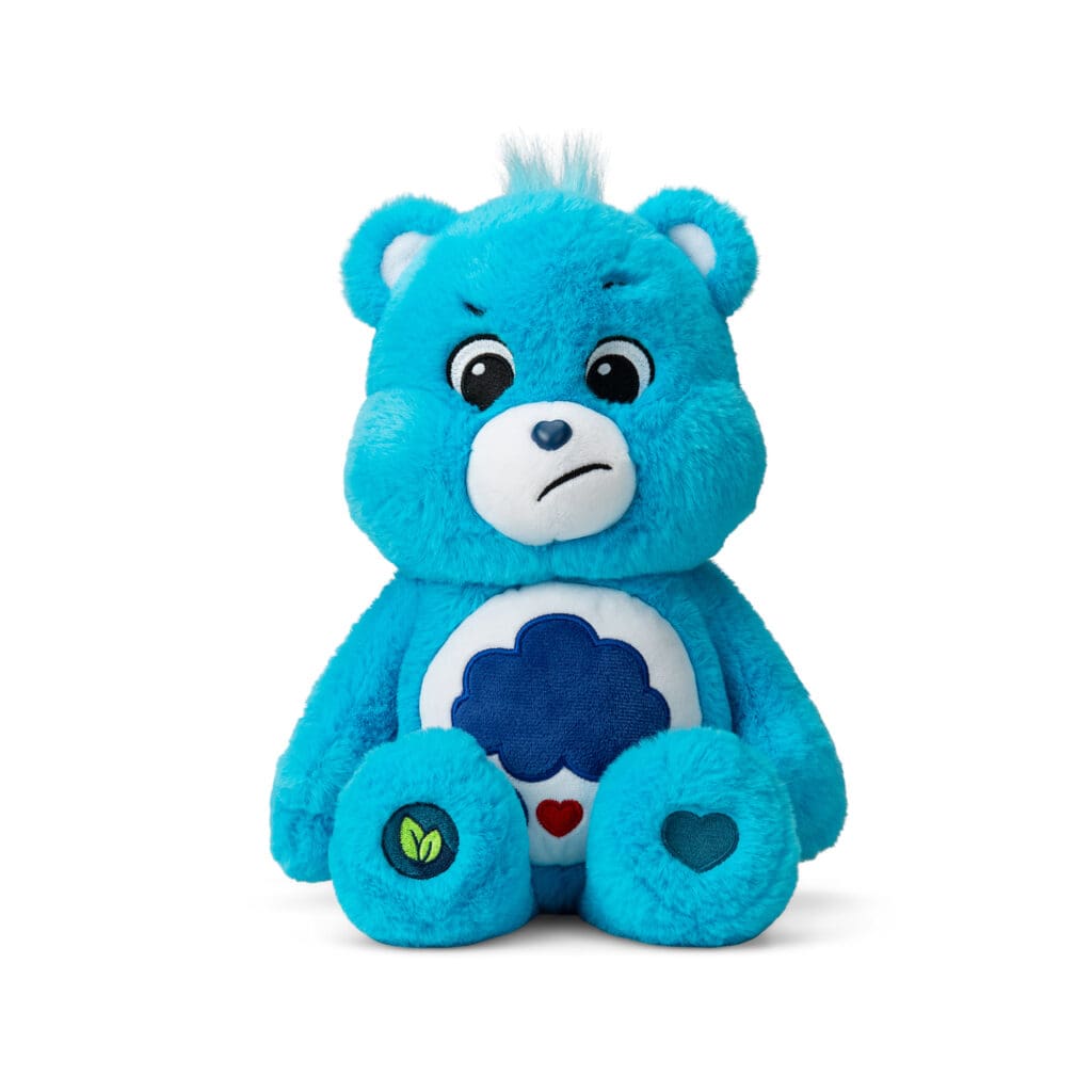 A blue Grumpy Bear plush toy from the Care Bears collection is shown against a plain white background. The toy features a rain cloud with raindrops and hearts on its belly and a slightly frowning expression.