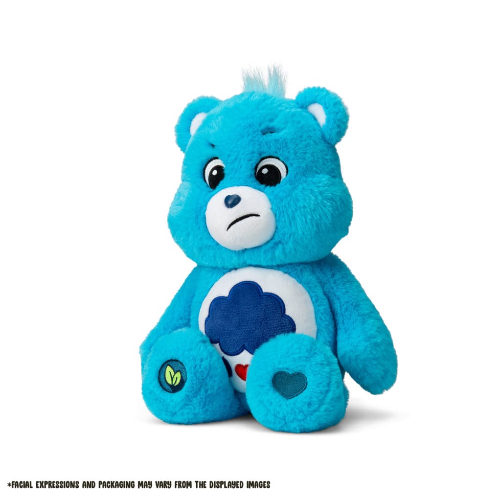 A blue Grumpy Bear plush toy from the Care Bears collection is shown against a plain white background. The toy features a rain cloud with raindrops and hearts on its belly and a slightly frowning expression.