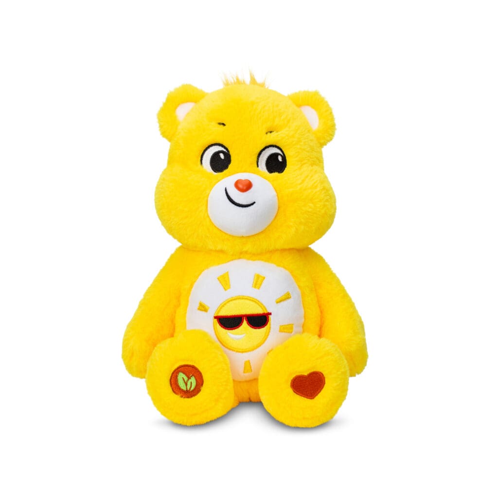 A yellow Funshine Bear plush toy from the Care Bears collection is shown against a plain white background. The toy features a smiling sun on its belly and has a cheerful expression.