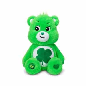 A green Good Luck Bear plush toy from the Care Bears collection is shown against a plain white background. The toy features a four-leaf clover on its belly and a cheerful expression.