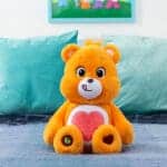 Orange Tenderheart Bear on bed.