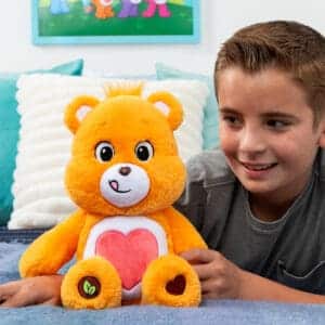 Orange Tenderheart Bear on bed with little boy.