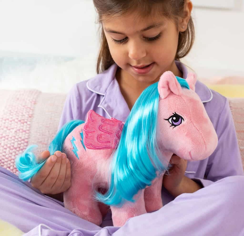 Girl with pink Pegasus My Little Pony plush with purple hair.