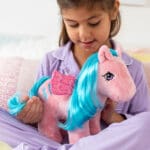 Girl with pink Pegasus My Little Pony plush with purple hair.