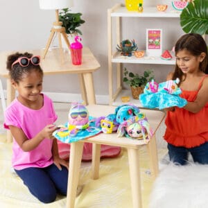 Cutetitos Islanditos plushies on a side table with two girls