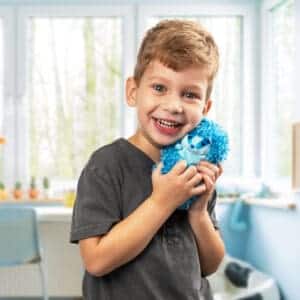 Young boy holding Curlimals Blue the Badger