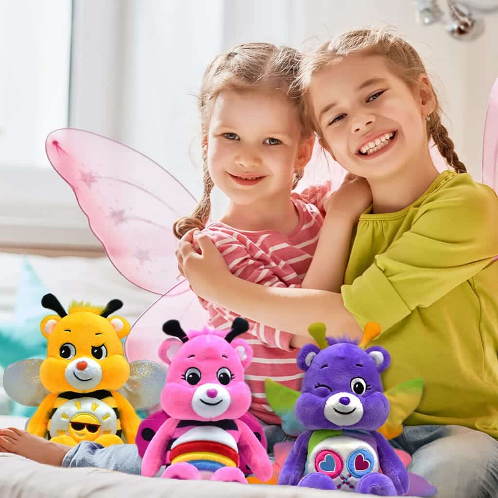 Three colored Spring Theme bee Funshine Bears are being played with by two young girls.
