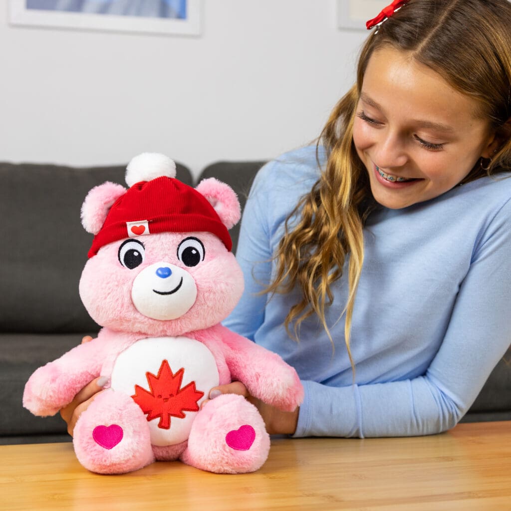 Young girl playing with Care Bear True North Bear on table.