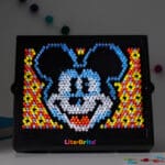 Lite Brite Disney 100 HD lit up on desk.