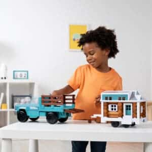 Kid with Lincoln Logs Tonka Tiny Home