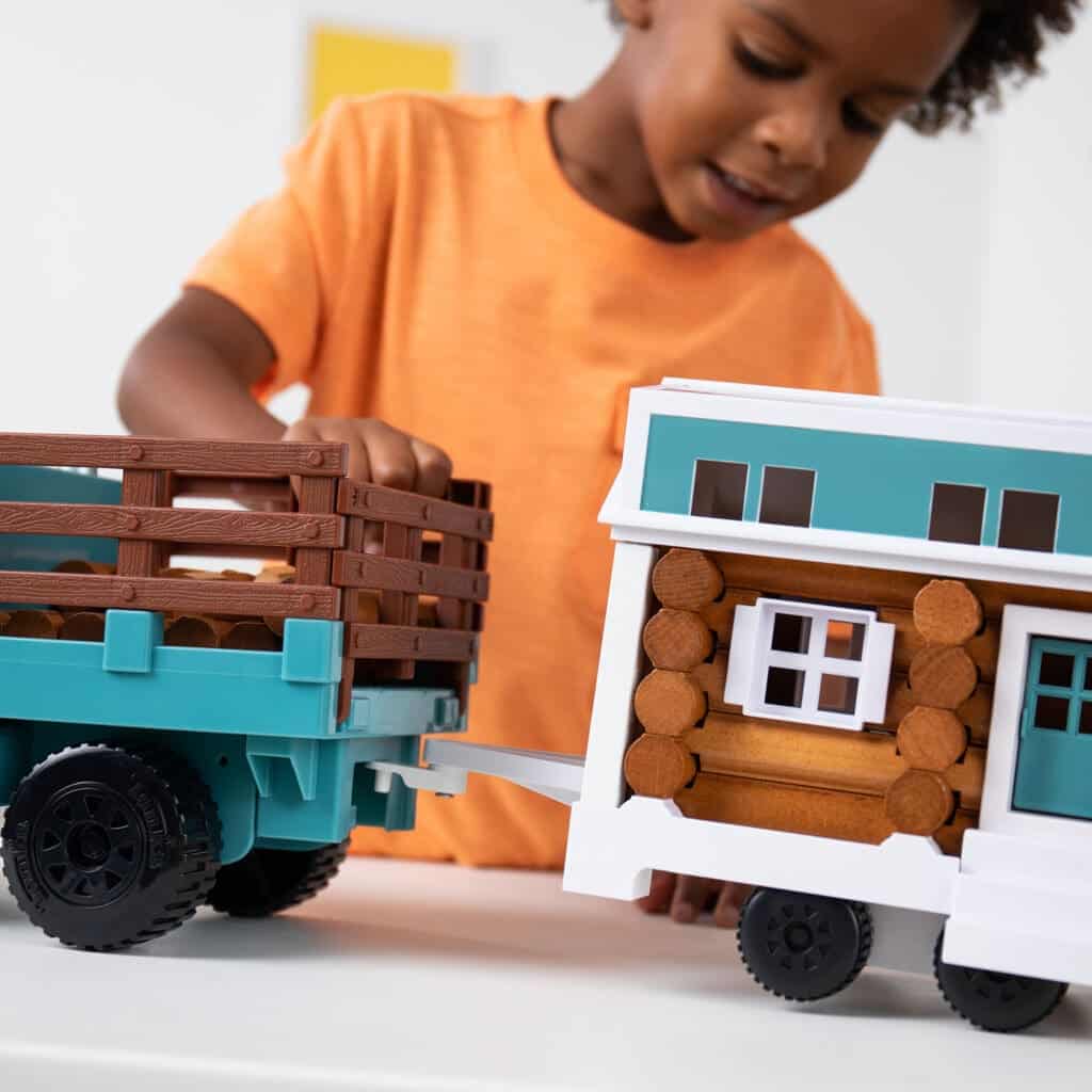 Young boy playing with Lincoln Logs Cruisin' Tonka & Tiny Home.