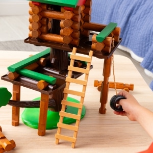 kid with lincoln logs treehouse