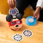 Young boy playing with View Master Mikey Mouse Deluxe Edition.