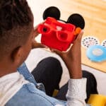 Young boy looking at View Master Mikey Mouse Deluxe Edition.