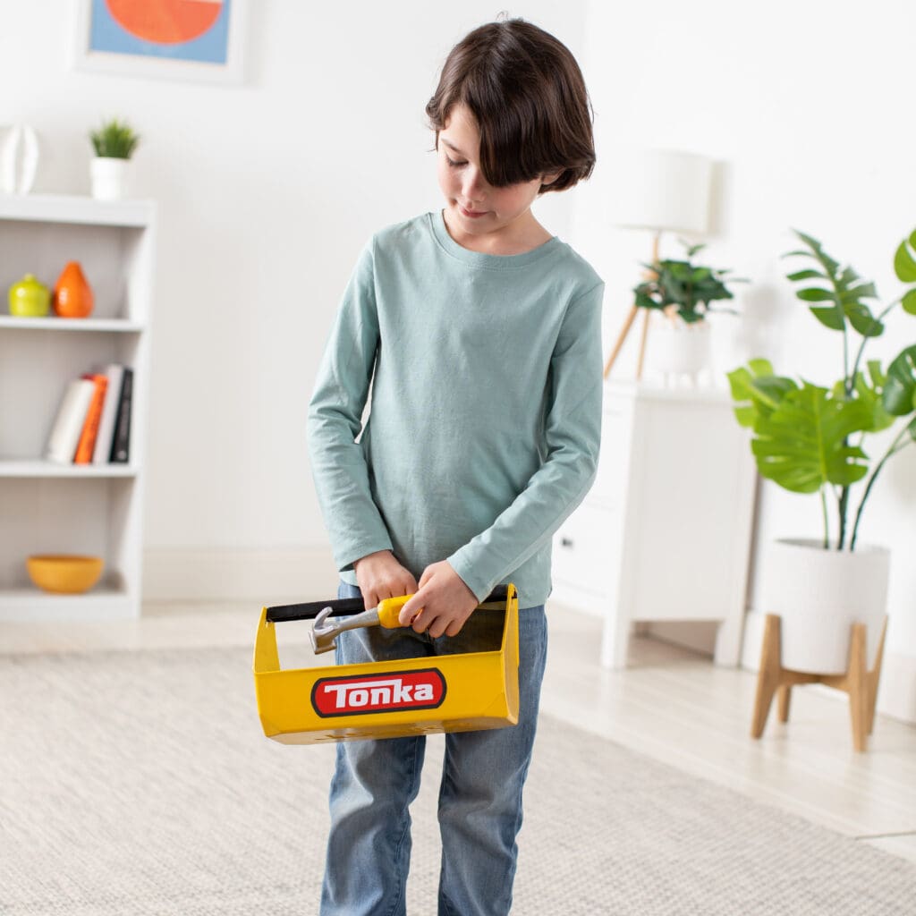 Young boy holding Tonka Tough Toolbox Set.