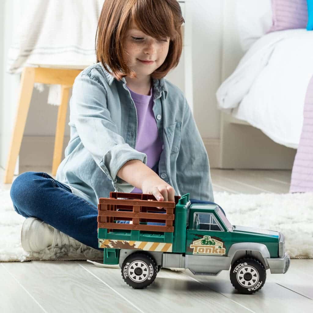 Young girl playing with Tonka Steel Classics Farm Truck.