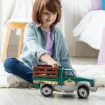 Young girl playing with Tonka Steel Classics Farm Truck.