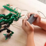 Young boy playing with Green K'nex K'nexosaurus Rex Motorized Building Toy.