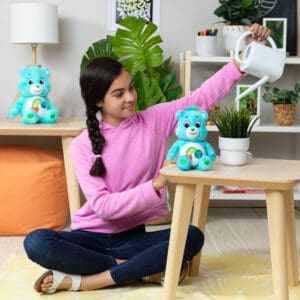Young girl with Care Bears Fun Size Plush in bedroom.