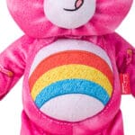 Close up of Care Bears Denim Share Bear, highlighting rainbow stomach emblem against white background.