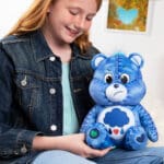 Young girl with Care Bears Denim Grumpy in her lap.