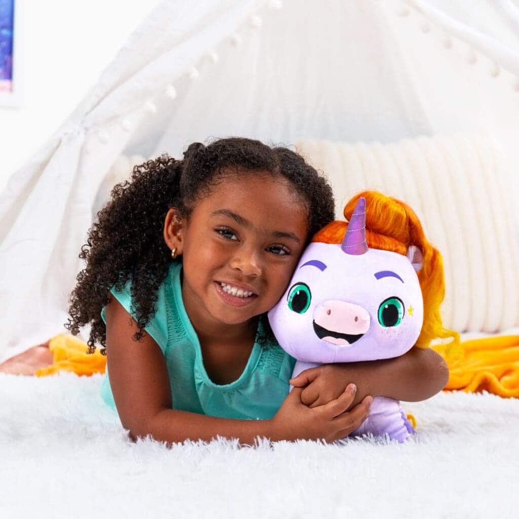 Not Quite Narwhal Jinglehooves Plushie being hugged by a young girl.