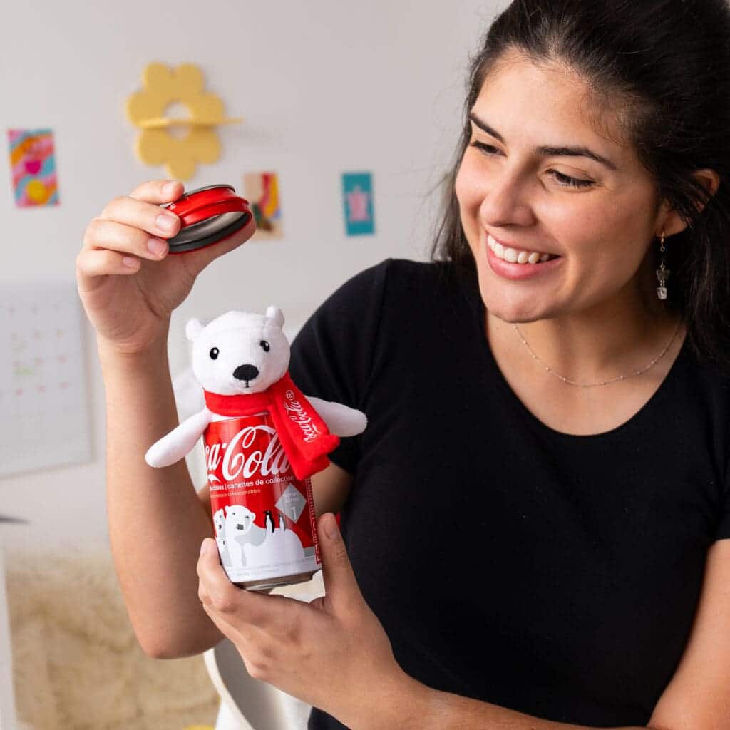 Young girl holding and playing with Coca-Cola Pop Can-polar bear.