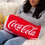 Coca-Cola Novelty Plush Can on young girls lap.