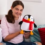 Young girl holding Coca-Cola Trendy Penguin.