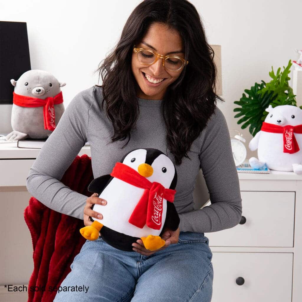 Young girl holding Coca-Cola Trendy Penguin.