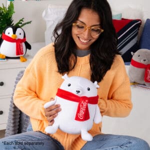 Young girl in room holding Coca-Cola Trendy Polar Bear.
