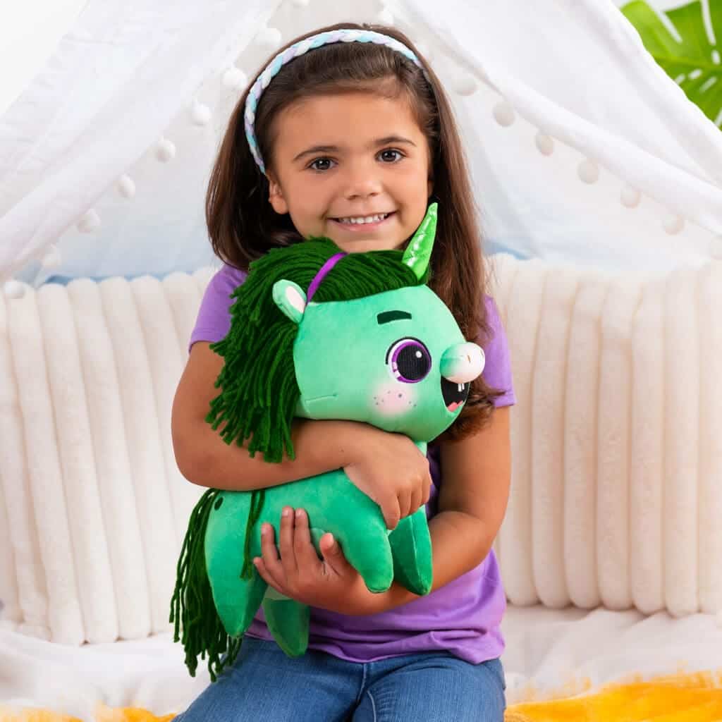 Not Quite Narwhal Juniper being hugged by young girl smiling.