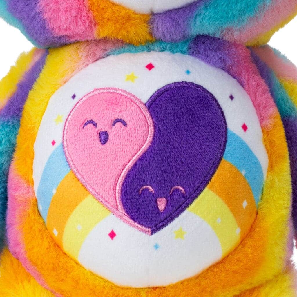 Close up of Care Bear Forever Bear's stomach, highlighting a purple and pink heart emblem.
