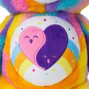 Close up of Care Bear Forever Bear's stomach, highlighting a purple and pink heart emblem.