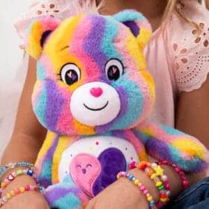 Care Bear Forever Bear being held by young girl.