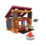 Display photo of the cabin from the front displaying the person, bear and firepit. All included in the Lincoln Logs Adventure Pod Cabin set