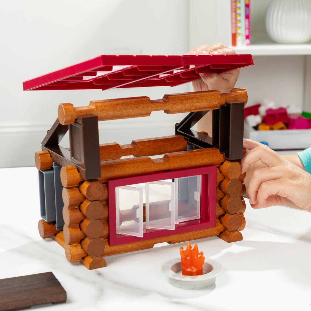 Photo of someone building the roof of the Lincoln Logs Adventure Pod Cabin