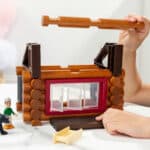 Photo of someone building the roof of the Lincoln Logs Adventure Pod Cabin