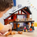 Close up of child playing with the Lincoln Logs Beechwood Retreat