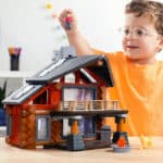 Child playing with the fully built Lincoln Logs Beechwood Retreat featuring the toy man in the childs hand
